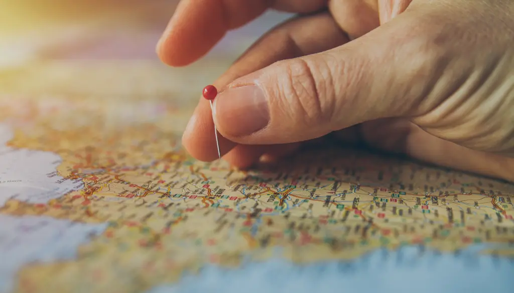 A finger tracing a route on a paper map.