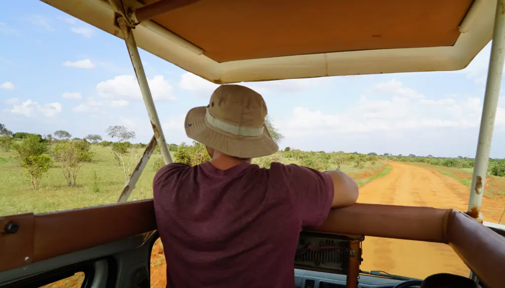 A traveller on a safari vehicle, looking out across the plains.